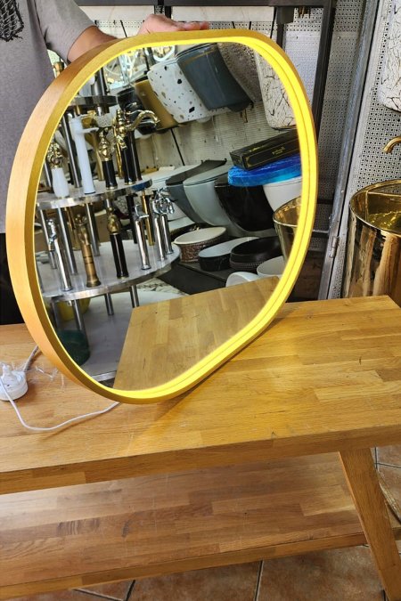 مرآة مضيئة بإطار ذهبي وحواف دائرية